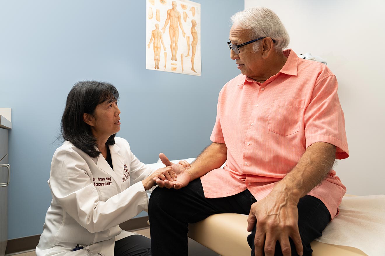 Acupuncturist Dr. Hung is consulting with a senior patient.